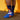 Person wearing blue socks with shark design against a yellow background 